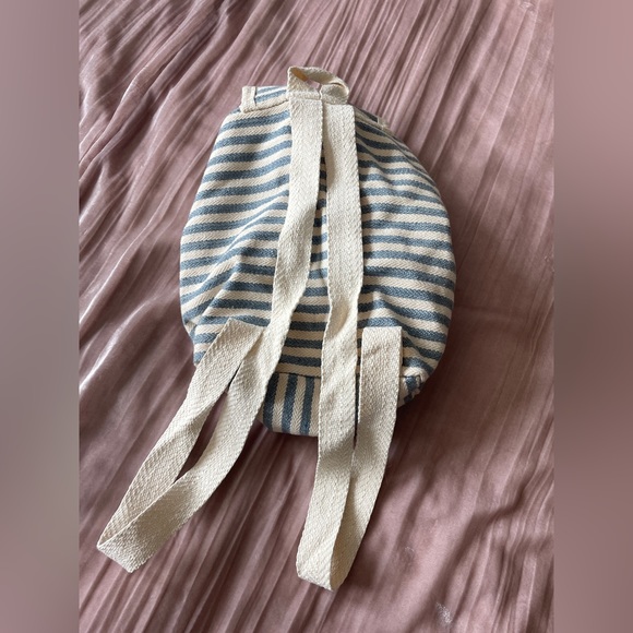 Striped blue and cream backpack with small zip pocket in front. - Picture 2 of 6